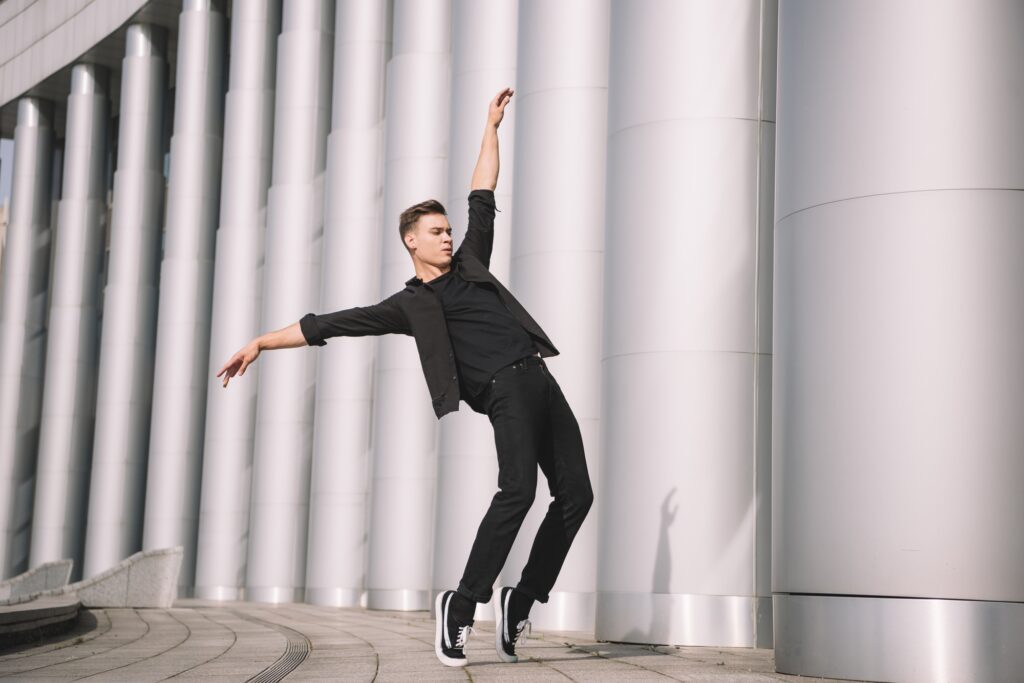 handsome young modern dancer dancing near columns