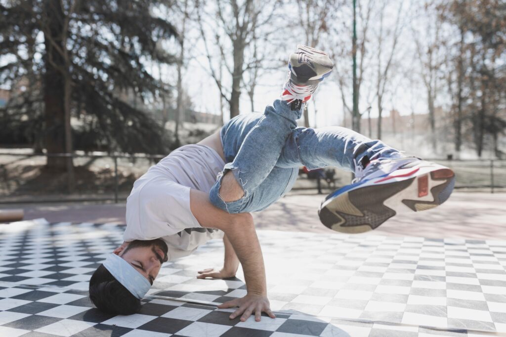 Handsome man dancing break dance in park
